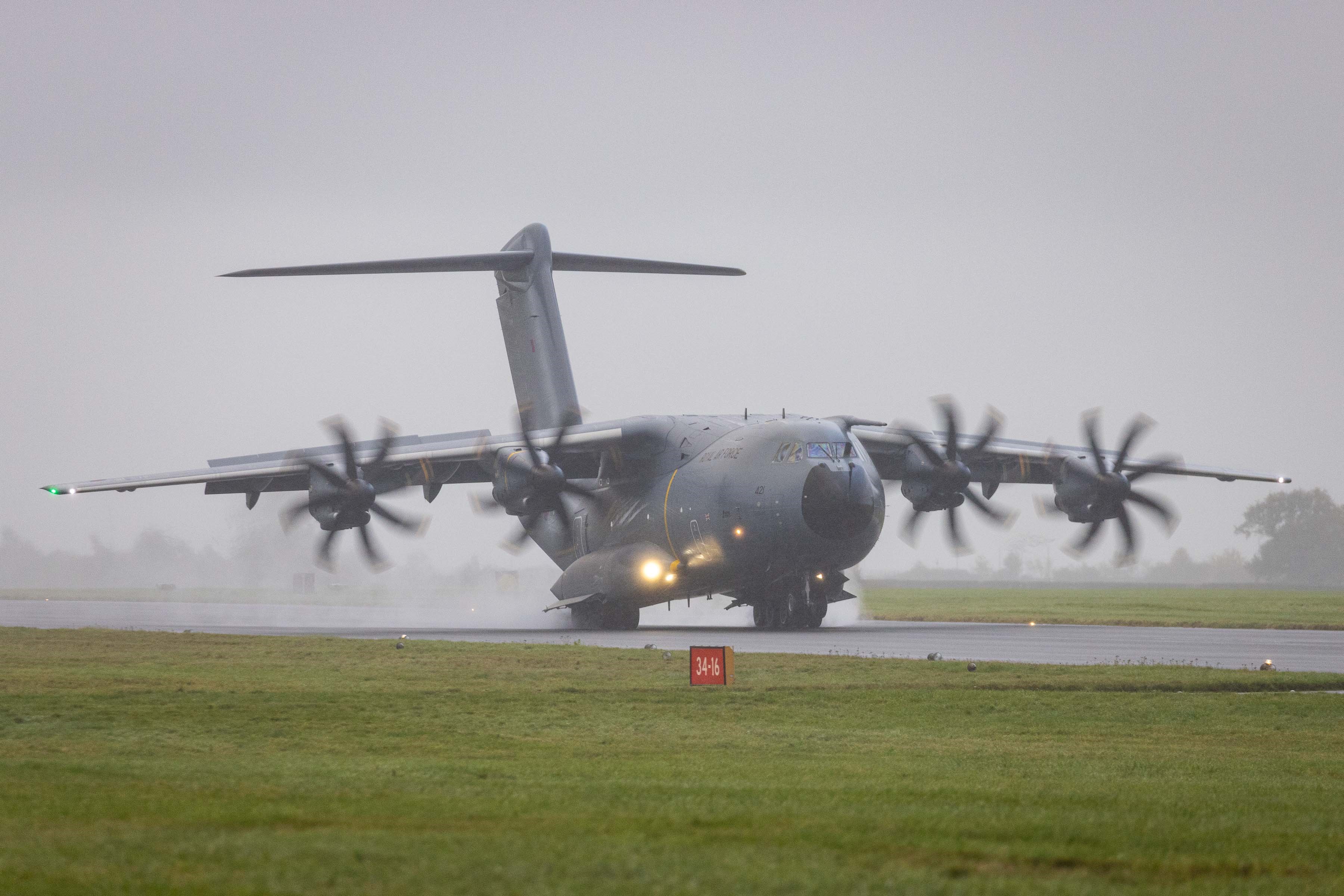 Photo - An Atlas aircraft on a wet runway, with plumes of spray in its wake